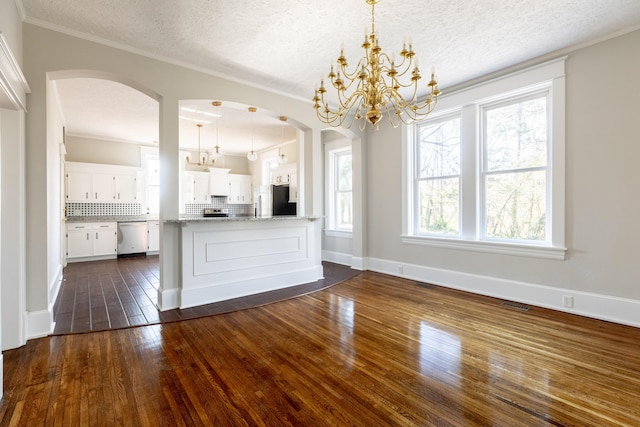 kitchen featuring appliances with stainless steel finishes, pendant lighting, white cabinetry, decorative backsplash, and dark wood-type flooring