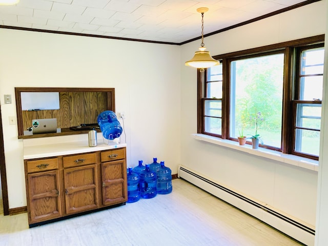 dining space with crown molding, light hardwood / wood-style floors, and a baseboard heating unit