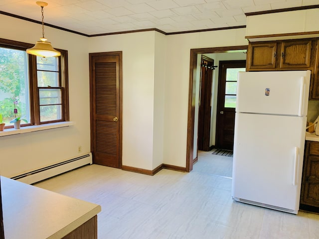 kitchen with baseboard heating, crown molding, hanging light fixtures, and white fridge