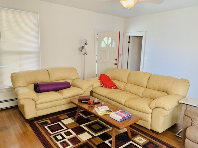 living room featuring dark hardwood / wood-style flooring, ceiling fan, and baseboard heating