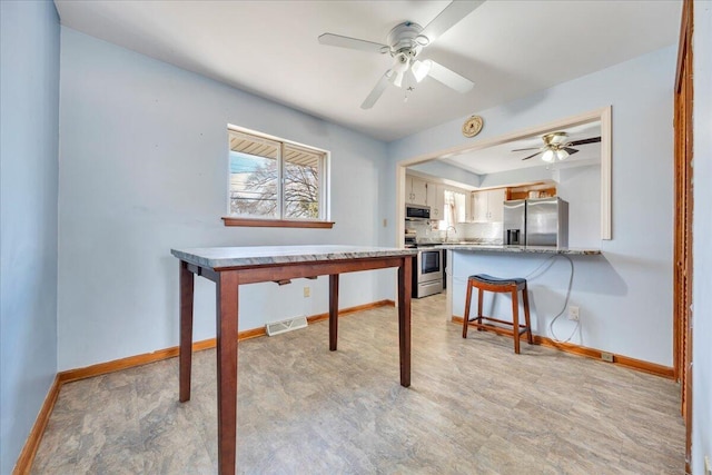 interior space featuring sink, ceiling fan, and light wood-type flooring