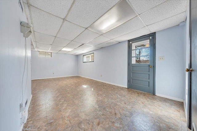 basement featuring a paneled ceiling and a wealth of natural light