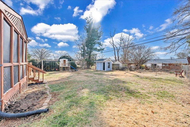 view of yard with a storage shed and a playground