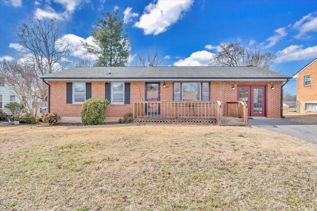 ranch-style home featuring french doors and a front lawn