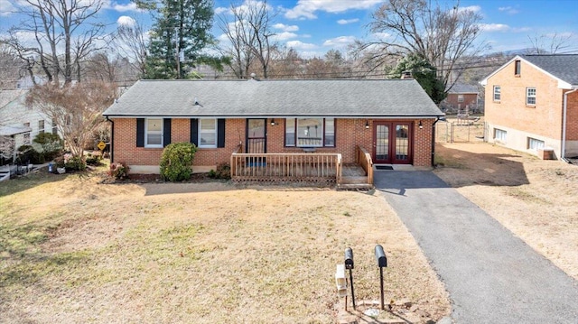 ranch-style house with a front yard, french doors, and covered porch