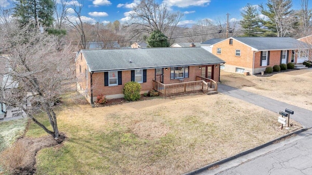 ranch-style house with covered porch and a front lawn