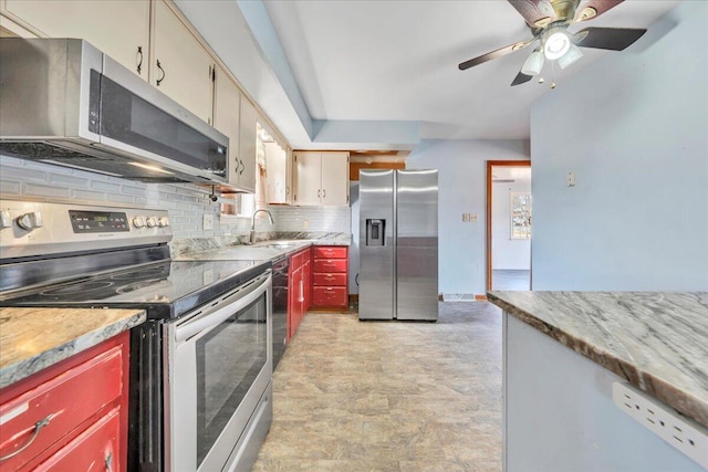 kitchen with sink, ceiling fan, stainless steel appliances, decorative backsplash, and cream cabinetry