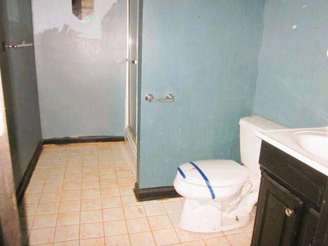 bathroom with vanity, an enclosed shower, tile patterned floors, and toilet