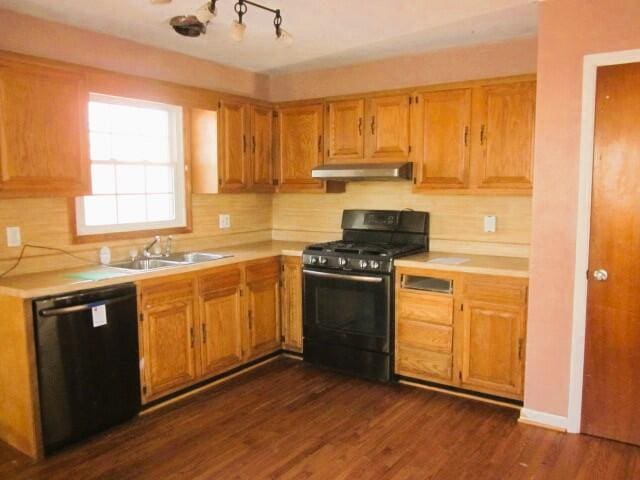 kitchen with dark wood-type flooring, sink, decorative backsplash, and black appliances