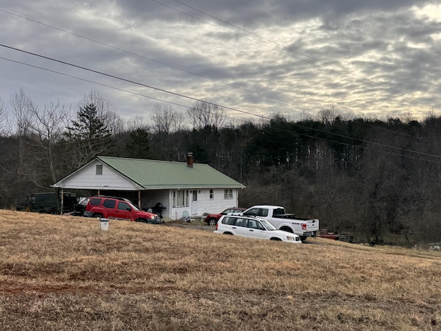 view of front of property with a carport and a front lawn