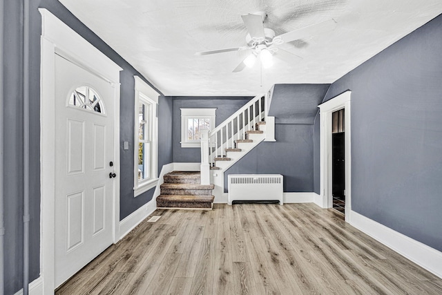 entryway with ceiling fan, radiator, and light wood-type flooring