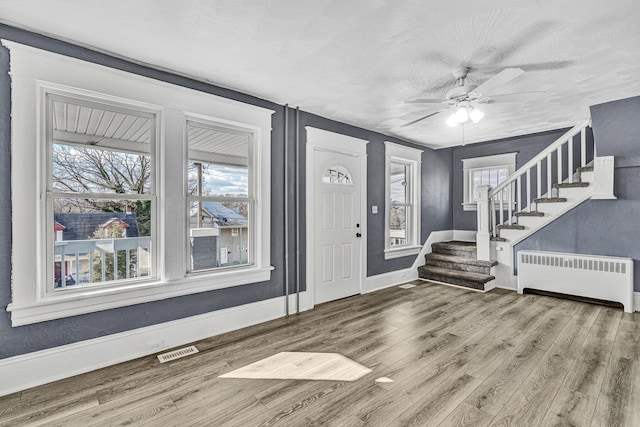 foyer featuring radiator, hardwood / wood-style flooring, and ceiling fan