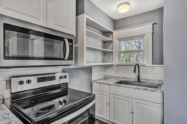 kitchen featuring white cabinetry, sink, light stone counters, and stainless steel appliances