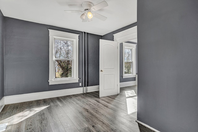 empty room with ceiling fan and hardwood / wood-style floors