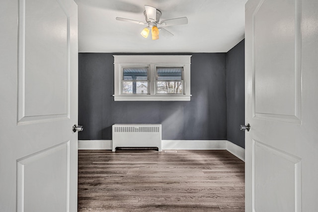 unfurnished room featuring ceiling fan, radiator, and hardwood / wood-style floors