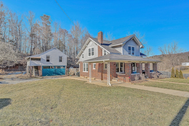 view of front of house featuring a garage, covered porch, and a front lawn