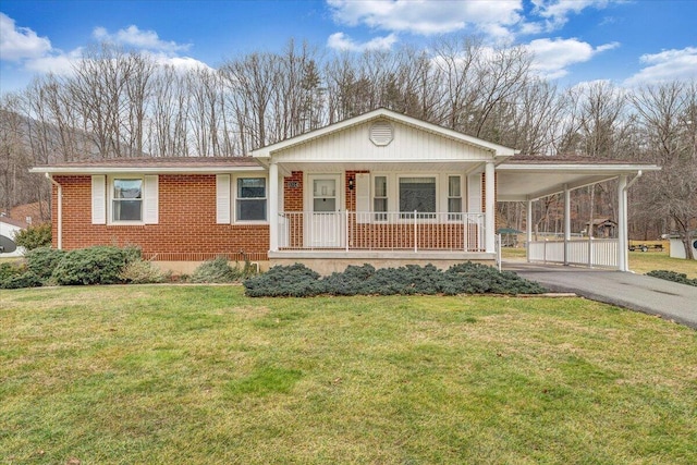 view of front of property featuring a carport, covered porch, and a front lawn