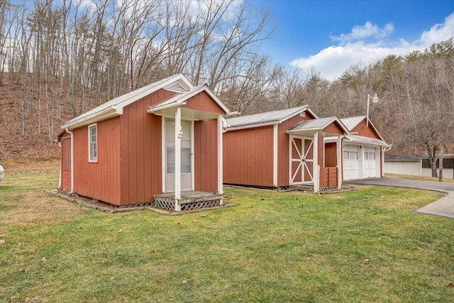 view of outdoor structure featuring a garage and a yard