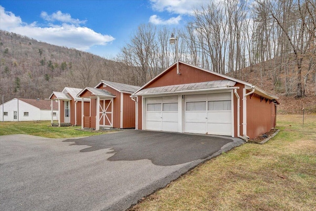 view of front of home with an outbuilding, a mountain view, a garage, and a front yard