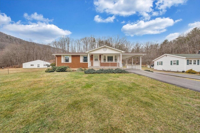 view of front of property featuring a front yard, a carport, and covered porch