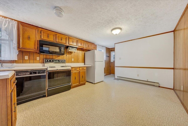 kitchen featuring a baseboard heating unit, ornamental molding, black appliances, a textured ceiling, and wood walls