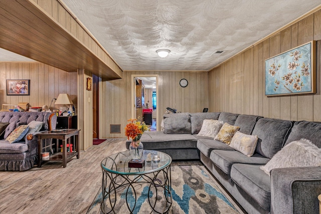 living room featuring hardwood / wood-style flooring and wood walls