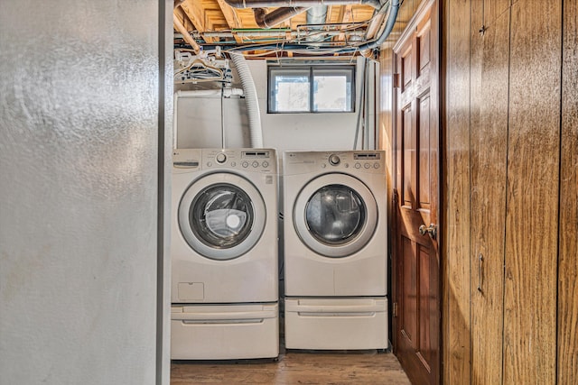 clothes washing area featuring independent washer and dryer and wood-type flooring