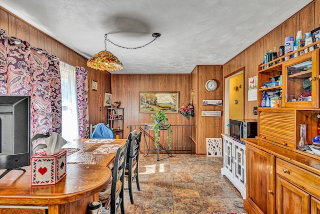 dining space featuring wood walls