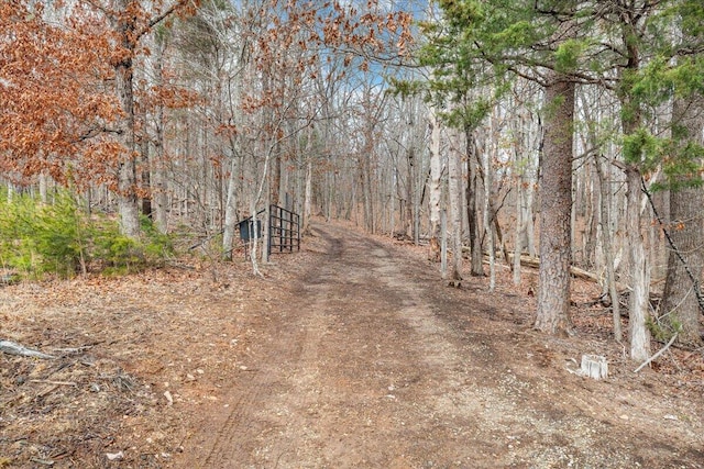 view of road featuring a gated entry and a view of trees