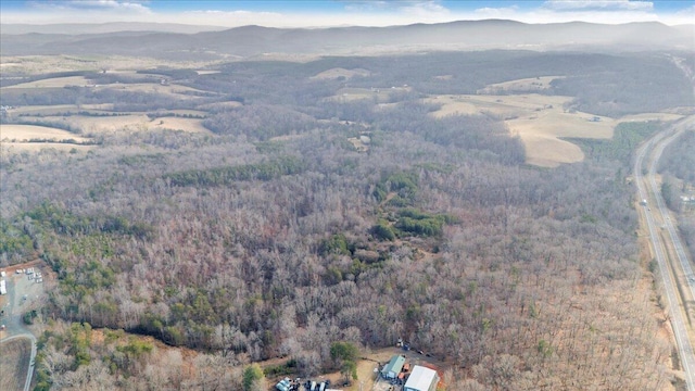 drone / aerial view featuring a mountain view and a view of trees