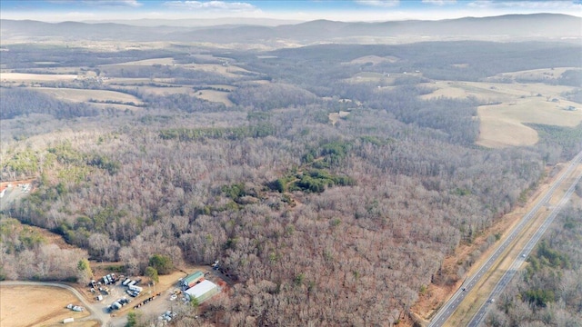 birds eye view of property featuring a forest view and a mountain view