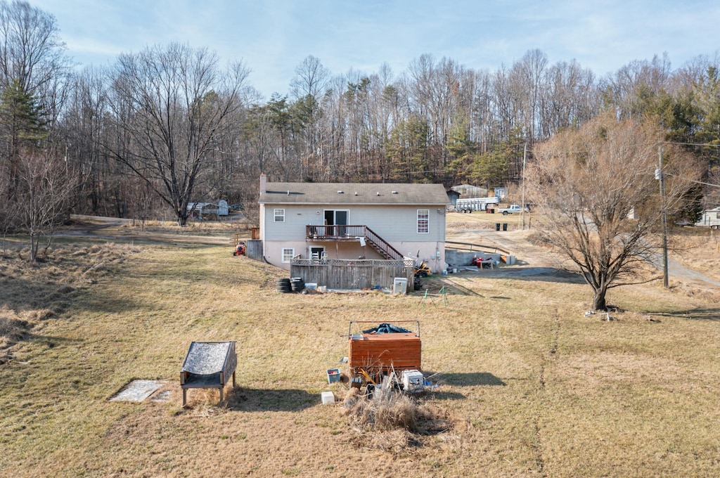 rear view of house featuring a yard and a deck