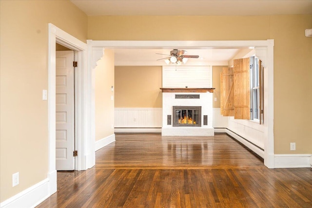 unfurnished living room featuring a fireplace, dark hardwood / wood-style floors, ceiling fan, and baseboard heating