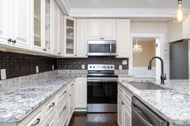 kitchen featuring hanging light fixtures, appliances with stainless steel finishes, sink, and dark hardwood / wood-style flooring