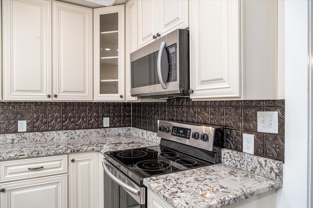 kitchen with white cabinetry, backsplash, and appliances with stainless steel finishes