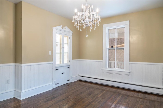 unfurnished room with an inviting chandelier, dark wood-type flooring, and baseboard heating