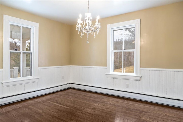 empty room featuring a baseboard radiator, a healthy amount of sunlight, and dark hardwood / wood-style flooring