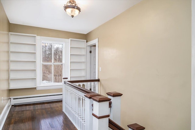 corridor featuring a baseboard heating unit and dark hardwood / wood-style flooring