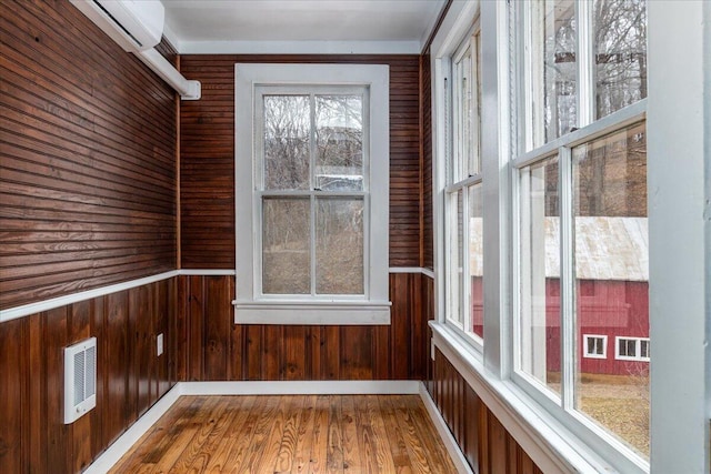 unfurnished sunroom featuring an AC wall unit