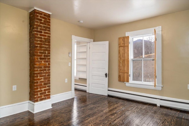 empty room featuring dark hardwood / wood-style flooring and baseboard heating