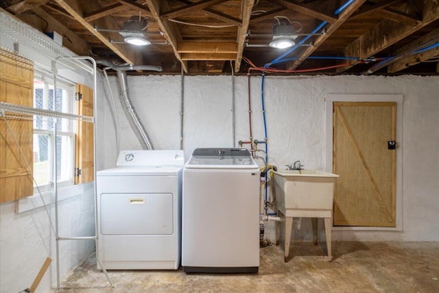 clothes washing area with separate washer and dryer and sink