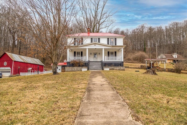 view of front of home with an outbuilding, a garage, a front yard, and covered porch