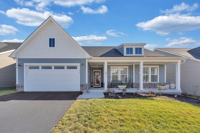 view of front of home with a garage, a front yard, and covered porch