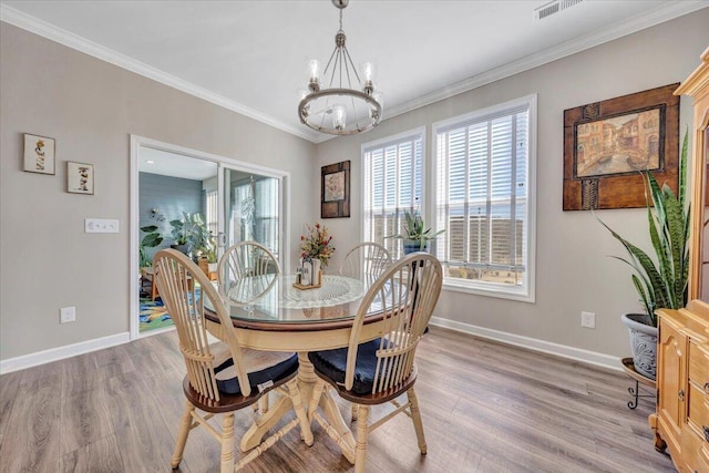 dining area featuring crown molding, an inviting chandelier, and hardwood / wood-style floors