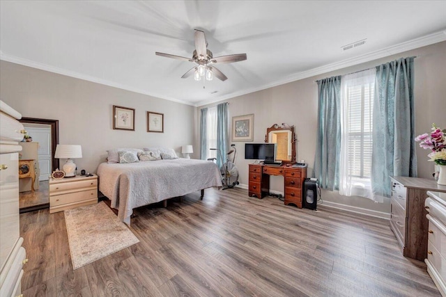 bedroom with ornamental molding, dark wood-type flooring, and ceiling fan