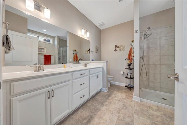 bathroom with vanity, toilet, and a shower with door