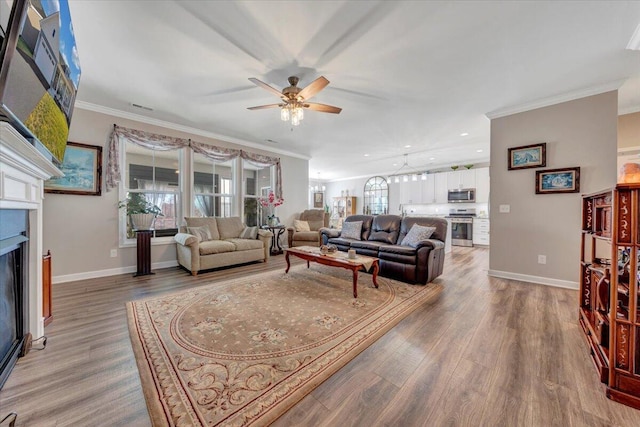 living room featuring hardwood / wood-style flooring, crown molding, and ceiling fan