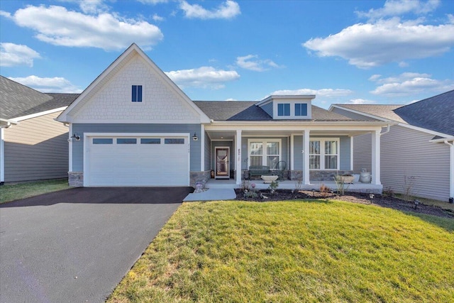 view of front of house featuring a garage, covered porch, and a front lawn