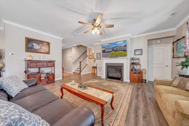 living room featuring hardwood / wood-style flooring, ceiling fan, and crown molding