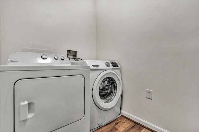 laundry room featuring washing machine and clothes dryer and wood-type flooring